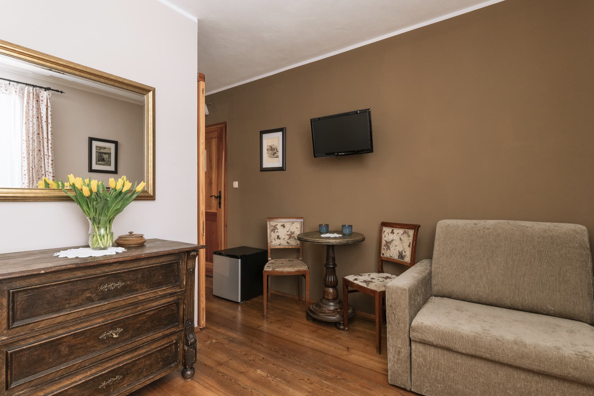 Seating corner with armchair, table and wall-mounted TV in room 5