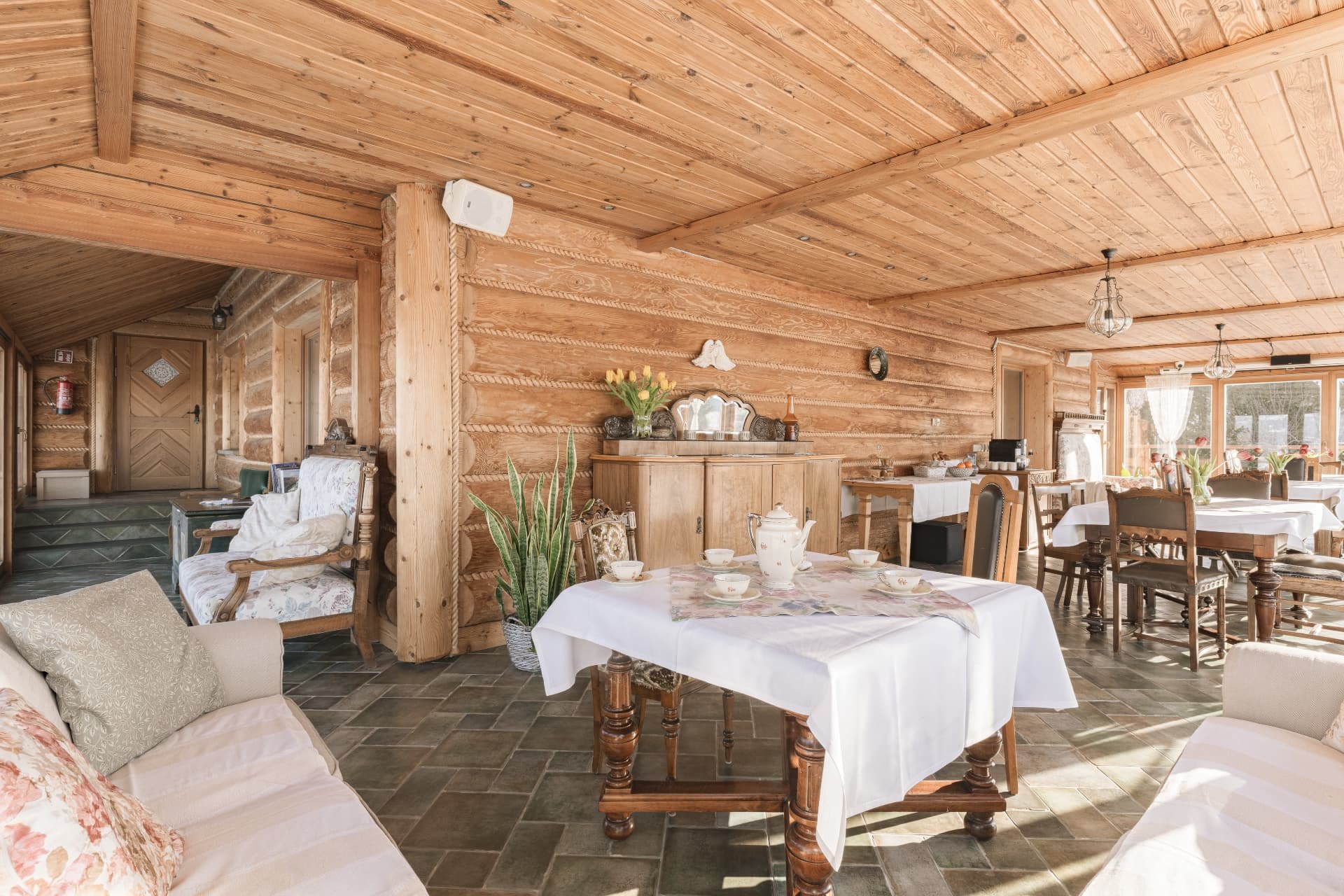 Timber lounge with sofas and a tea table beside the dining area