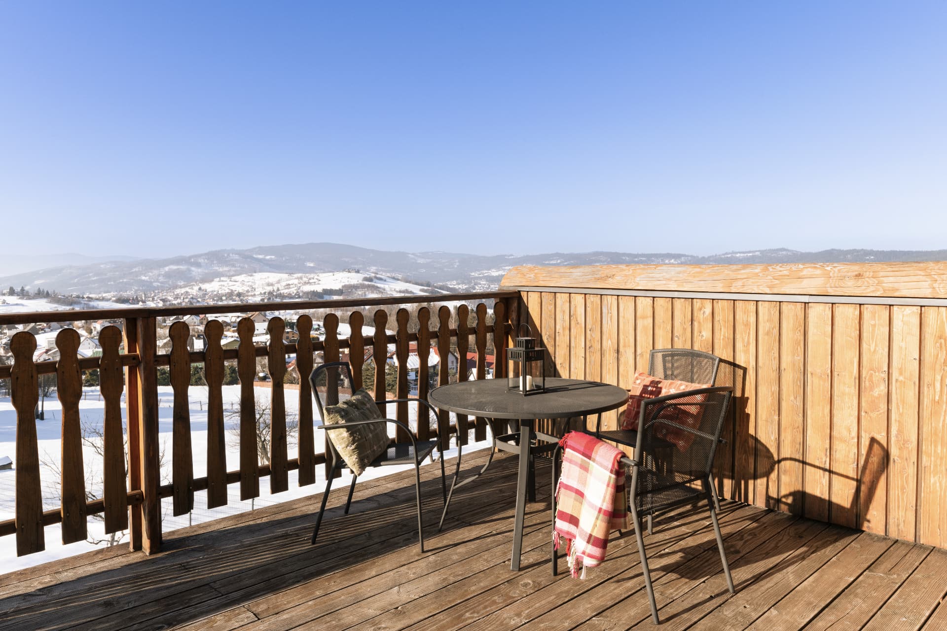 Balcony of room 3 with a table and blankets over the snowy Beskid mountains