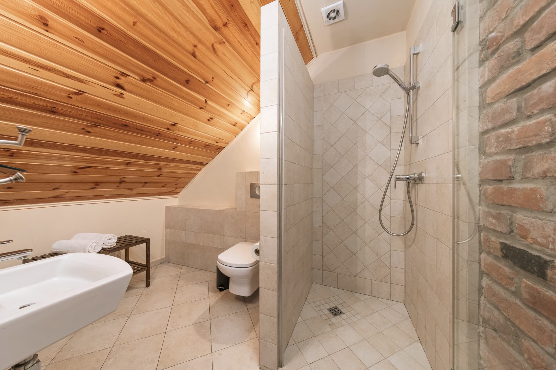 Bathroom of room 9 with a walk-in shower and a brick accent wall