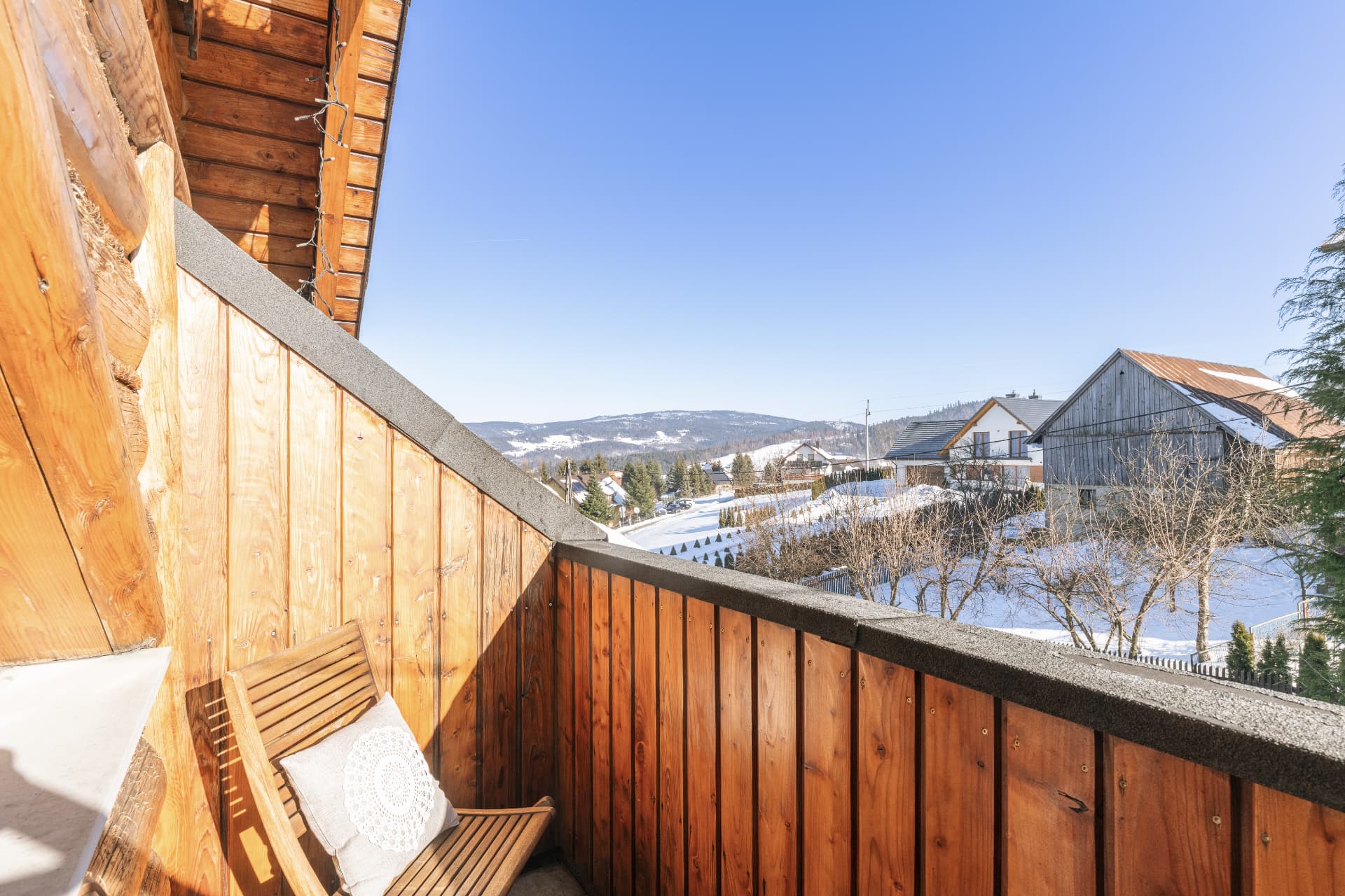 Balcony of room 10 with a lounge chair over the snowy hills and mountains