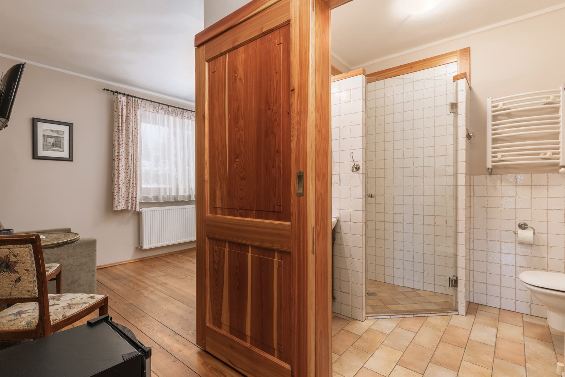 Sliding wooden door between the living space and bathroom in room 5