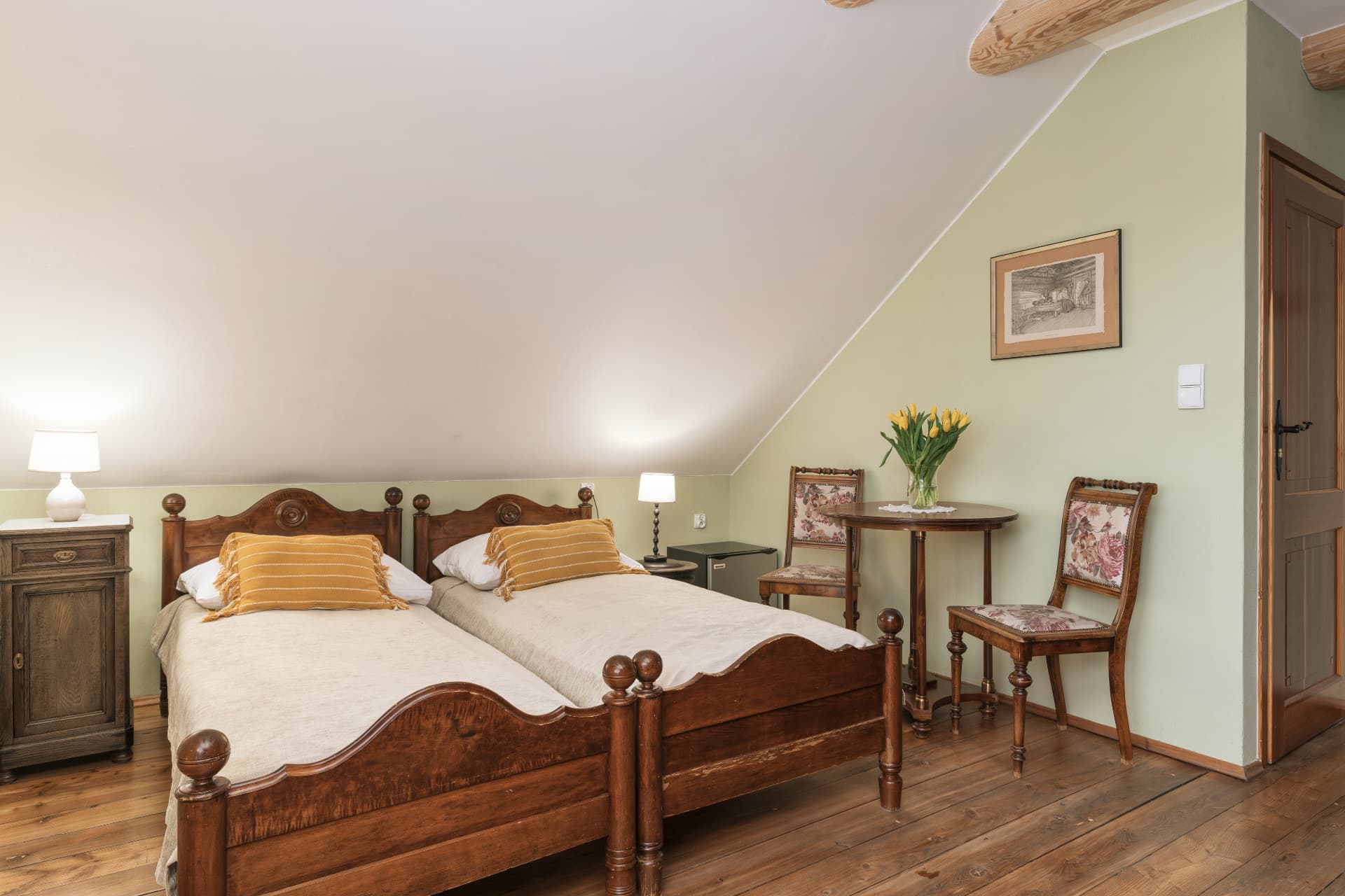 Bedroom of room 7 with two twin beds and a small seating table