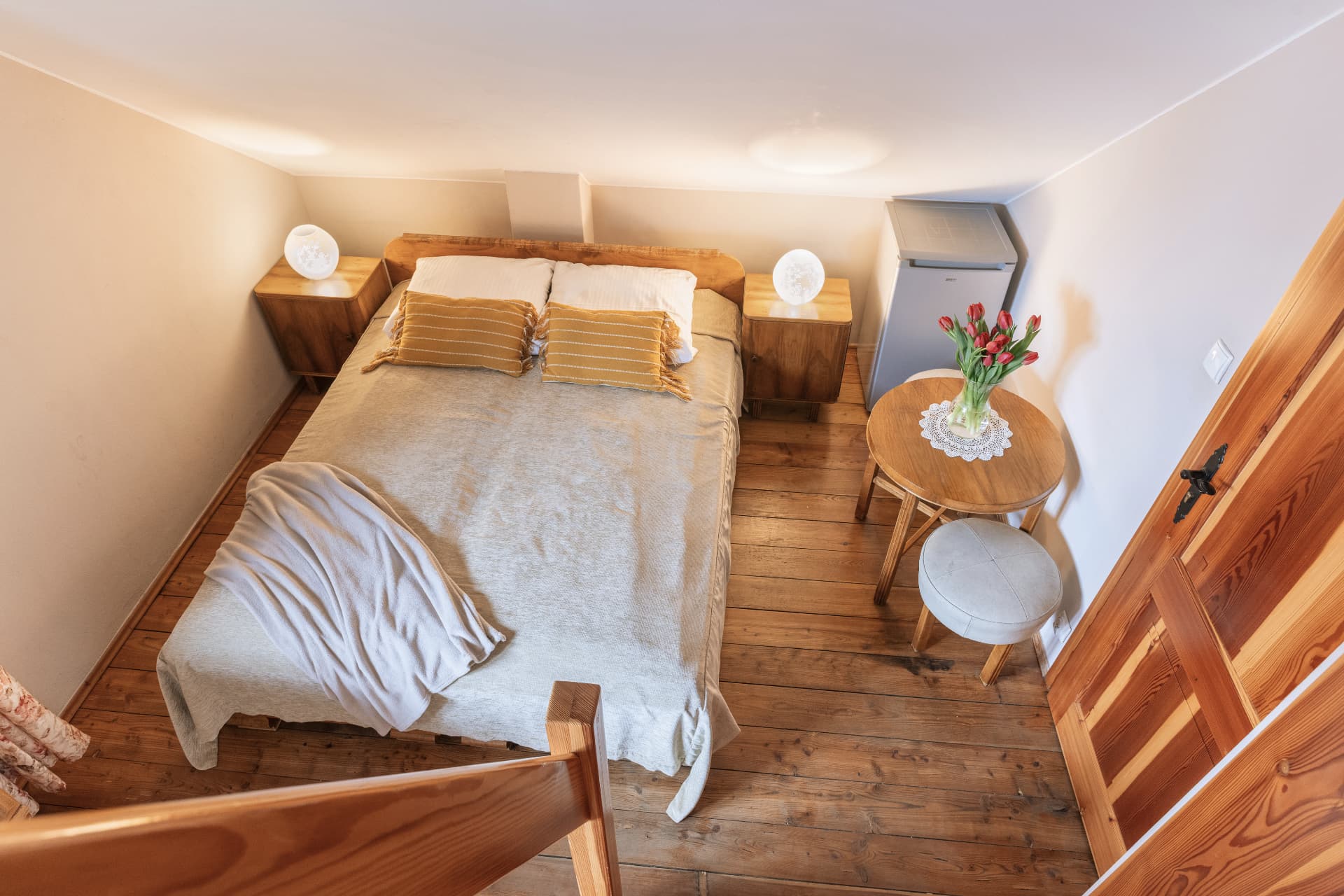 Sleeping area of room 9 seen from above with a small round table
