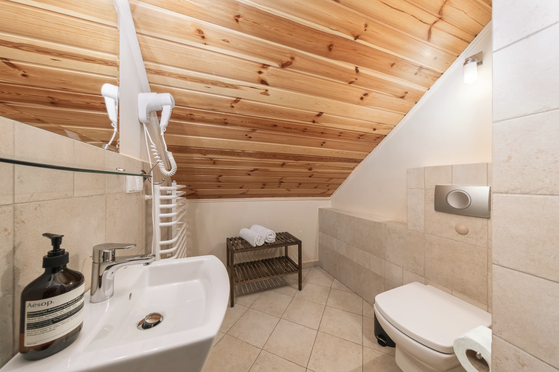 Bathroom of room 9 with a sink, mirror and wall-mounted hairdryer