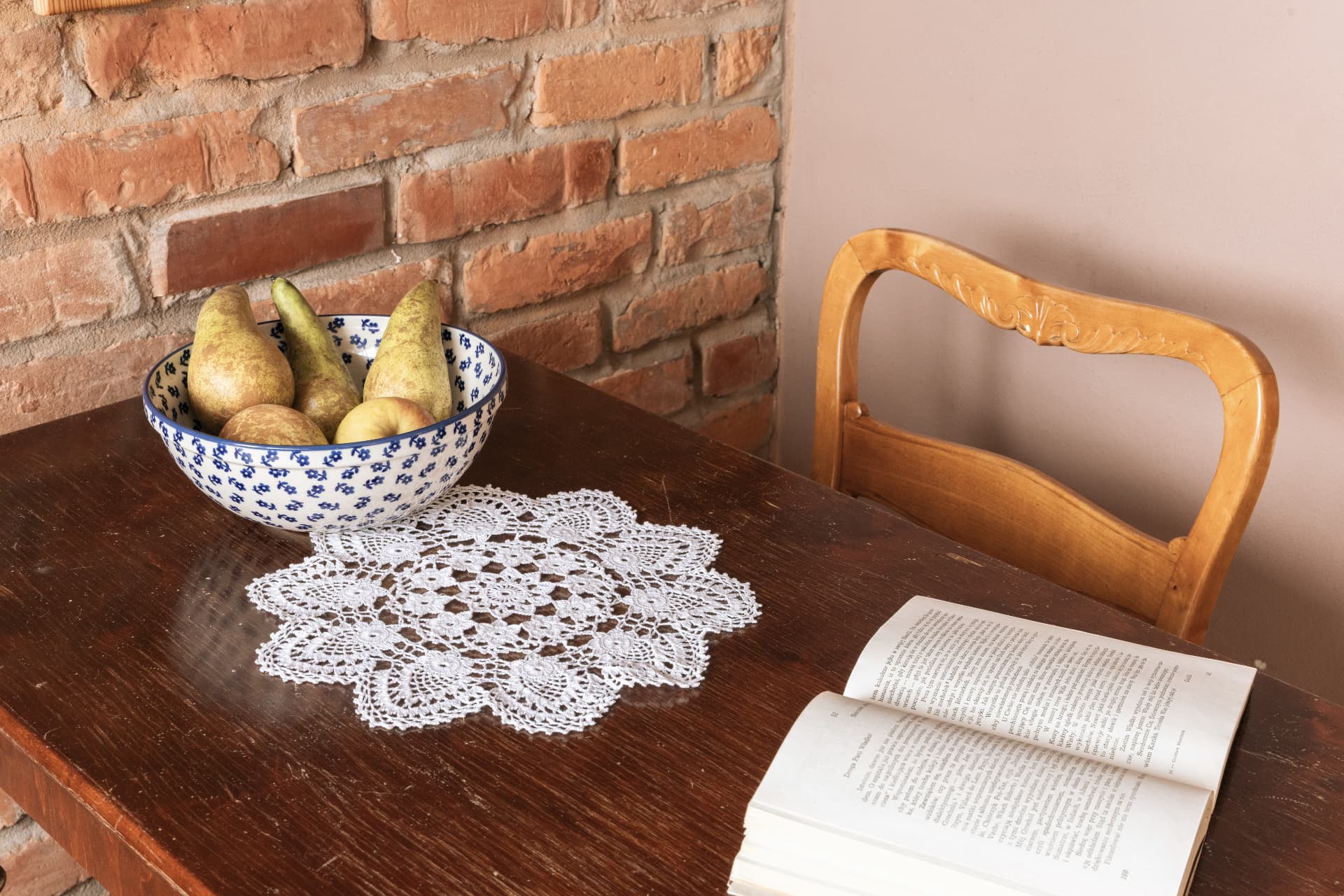 Seating corner of room 8 with a fruit bowl and an open book on the table