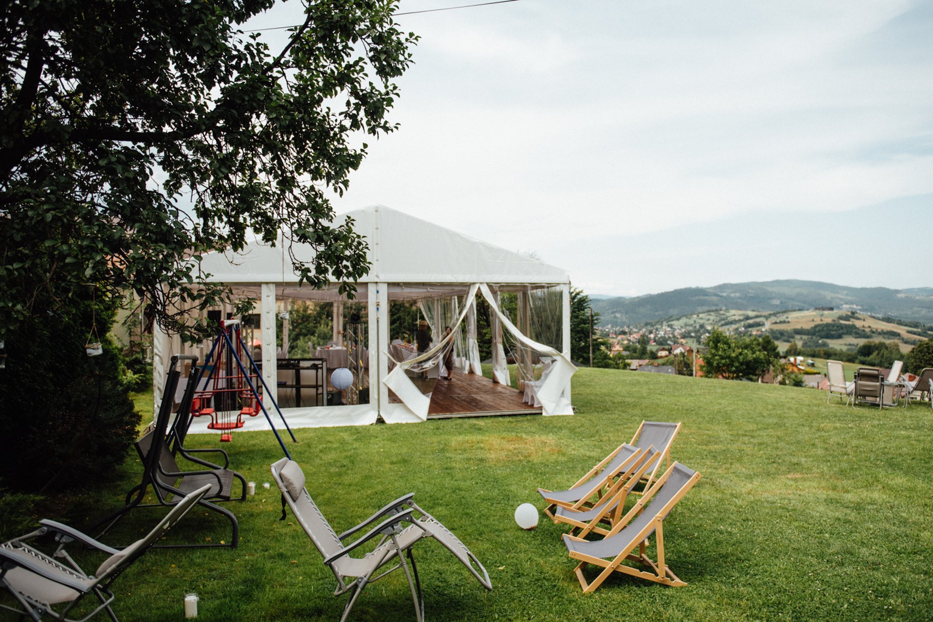 White wedding marquee on the lawn with lounge chairs overlooking the rolling hills