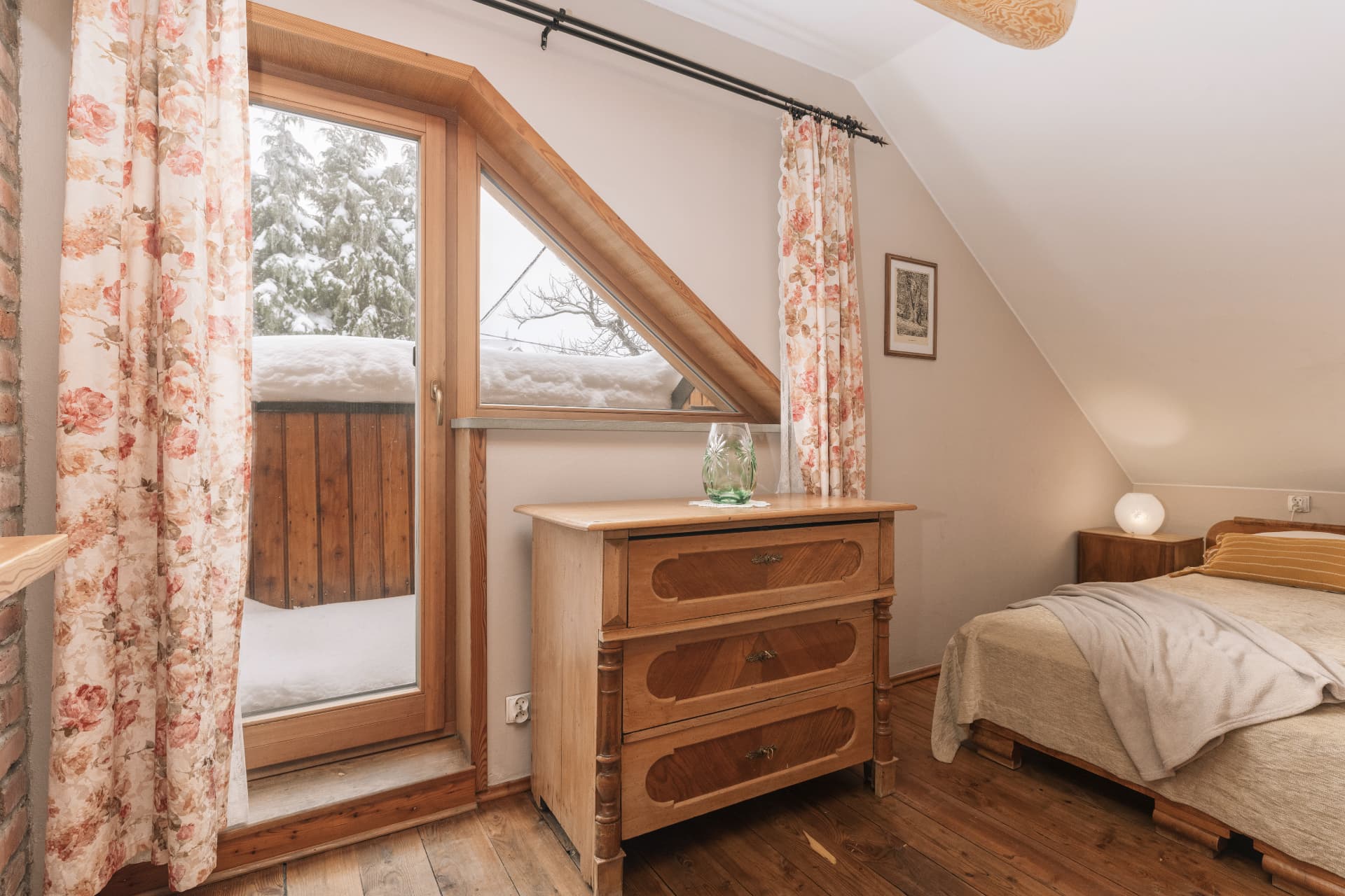 Bedroom of room 9 with a wooden chest of drawers and a window to the balcony
