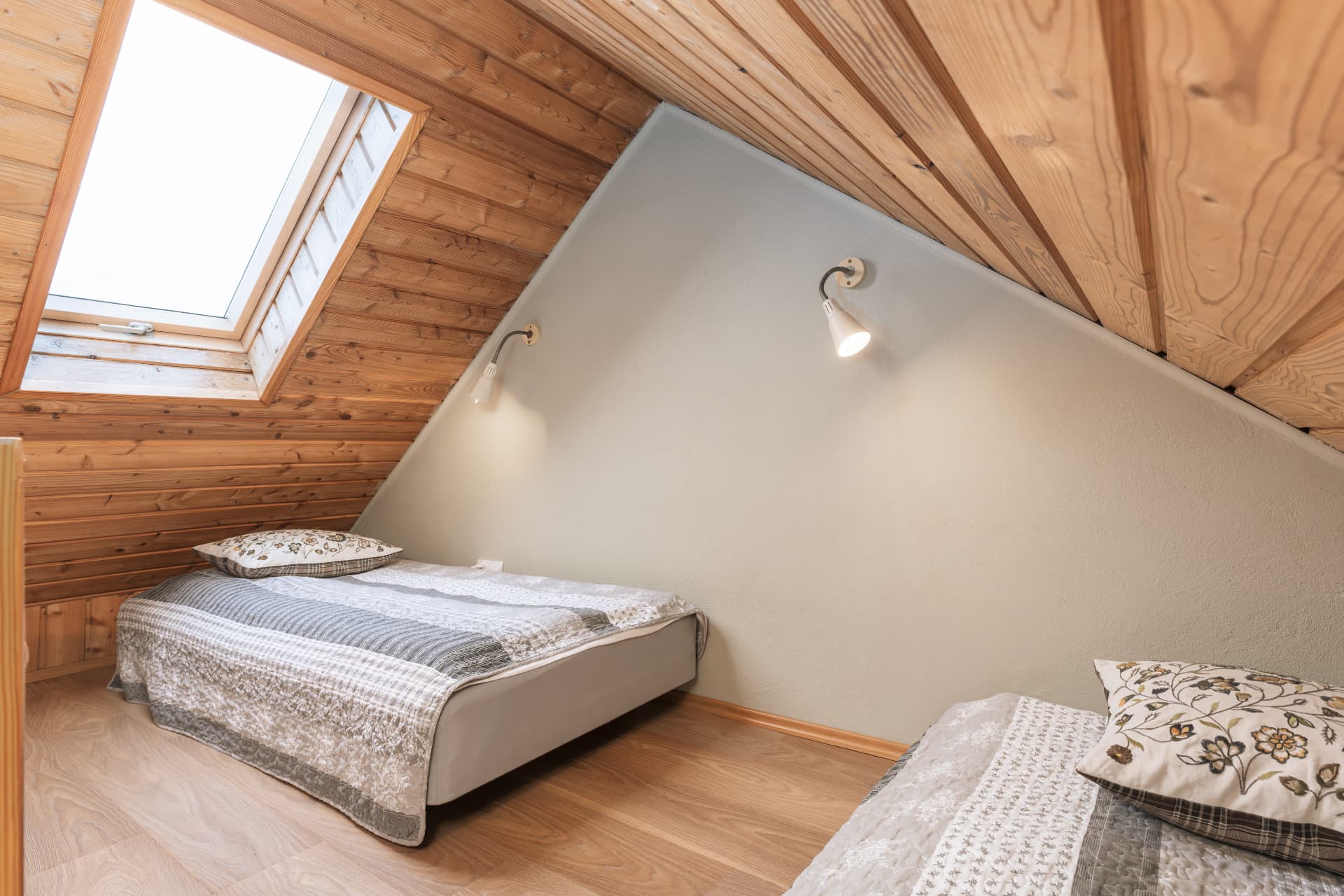 Attic sleeping area of room 7 with sloped wooden ceilings and a skylight