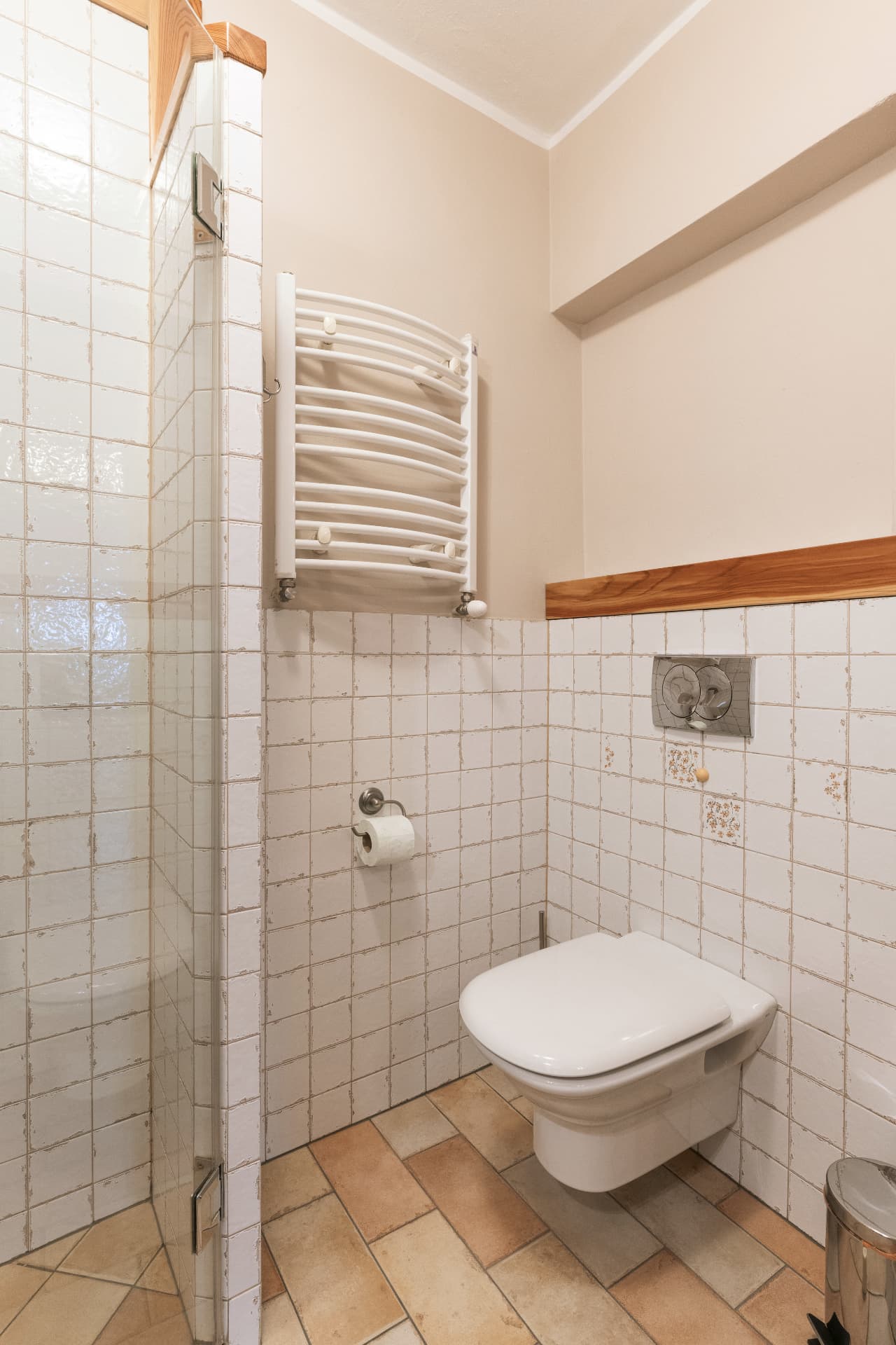 Bathroom of room 5 with a wall-hung toilet, towel rail and shower