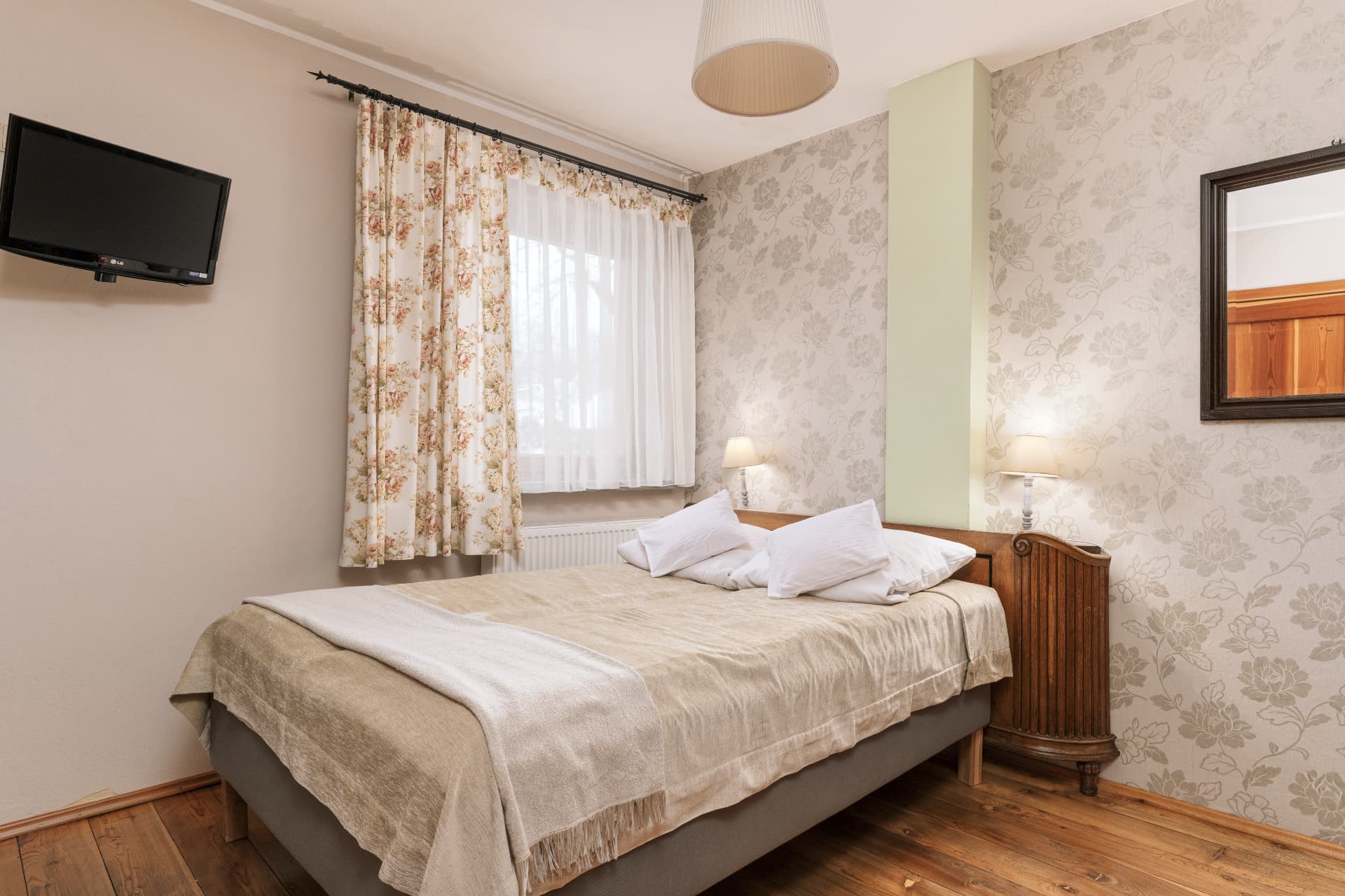 Main bedroom of room 6 with a double bed and wall-mounted TV