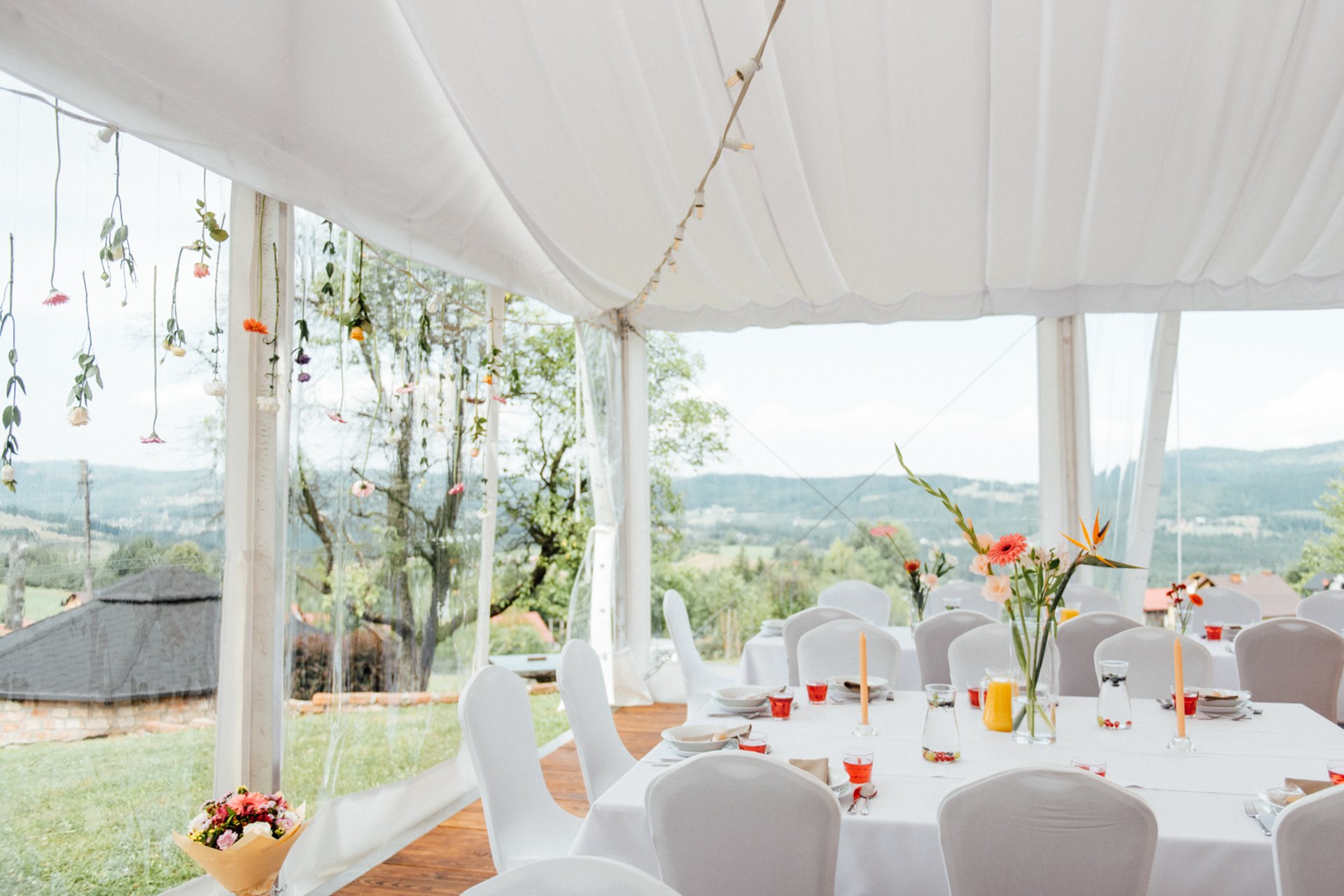 Inside the dining tent, mountain views through the clear walls and hanging floral decorations